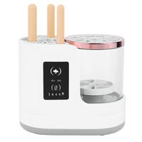 Electric makeup brush cleaner with three brushes inserted into the holder before washing