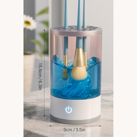 Electric makeup brush cleaner with brushes washing inside blue water, product dimensions shown: 15.8 cm (6.3 in) height and 9 cm (3.5 in) width.