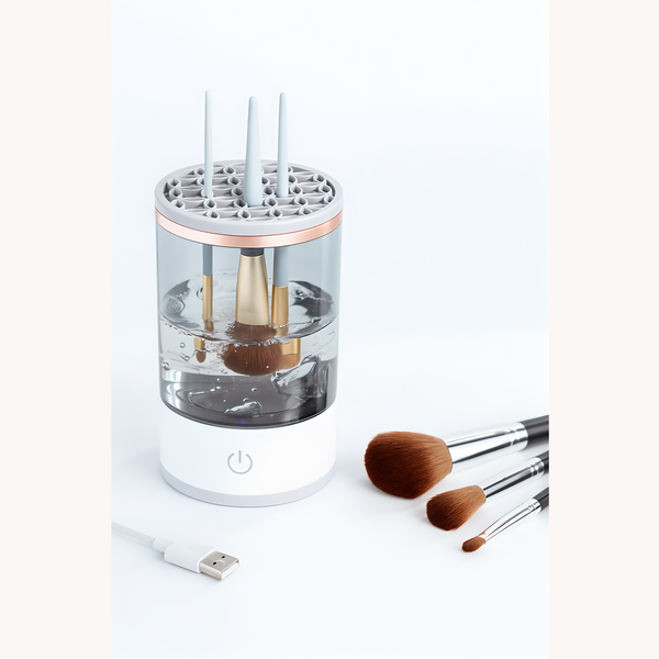 Electric makeup brush cleaner with USB charging, water-filled transparent container, and multiple brushes inside. Extra brushes are placed beside the device for demonstration.
